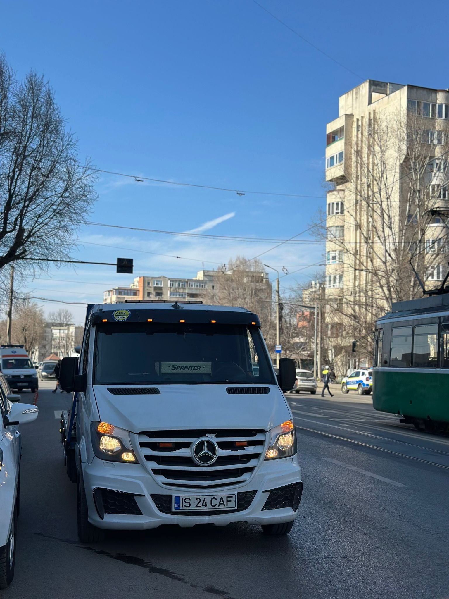 Autoplatforma in trafic pe un bulevard din Iasi, langa un tramvai verde