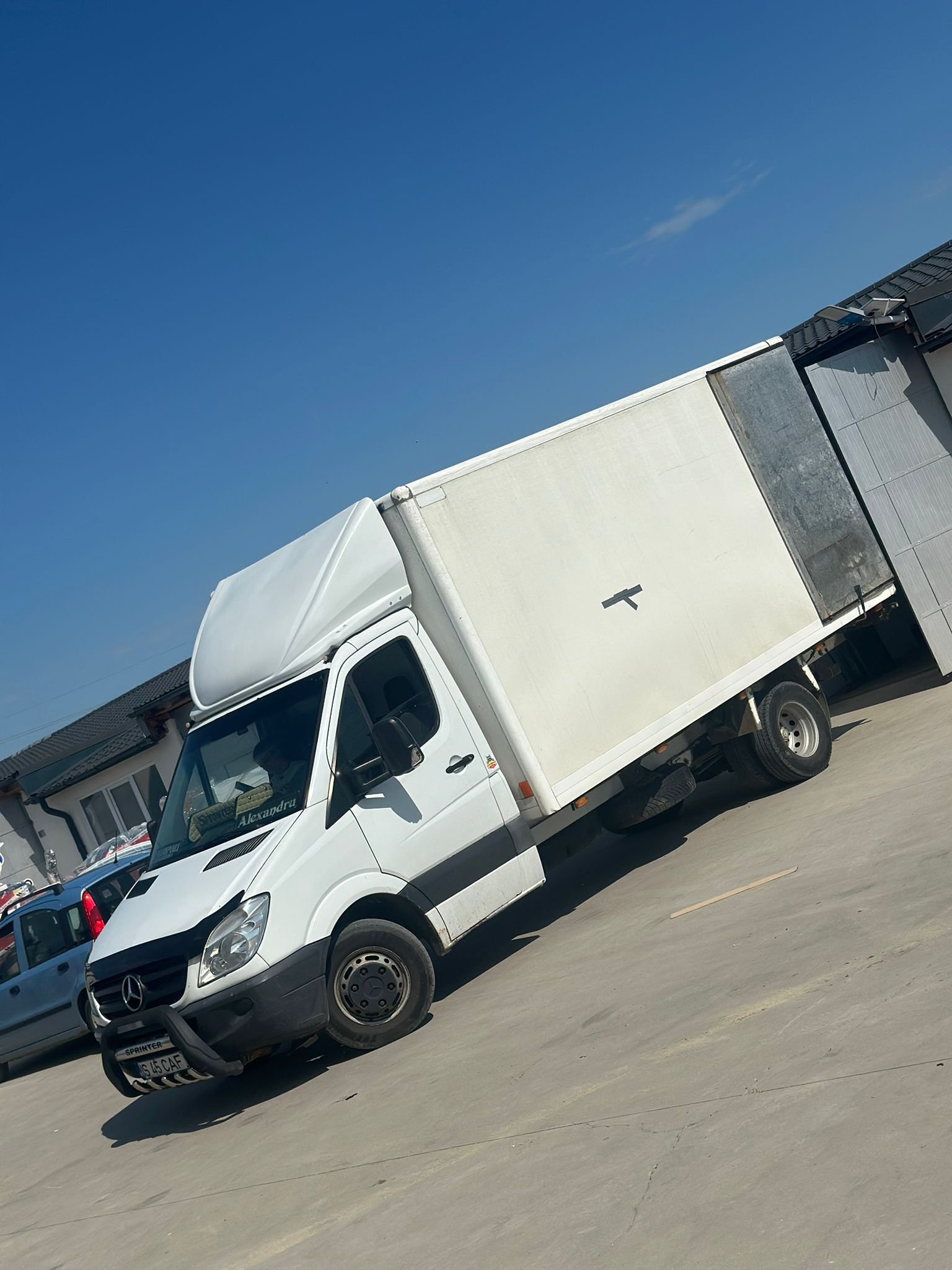 Camioneta Mercedes Sprinter cu cutie inchisa parcata in curtea firmei