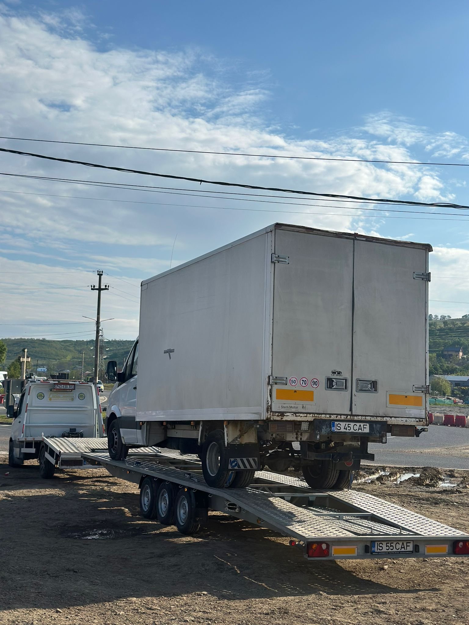 Camioneta cu cutie transportata pe remorca platforma pe marginea drumului