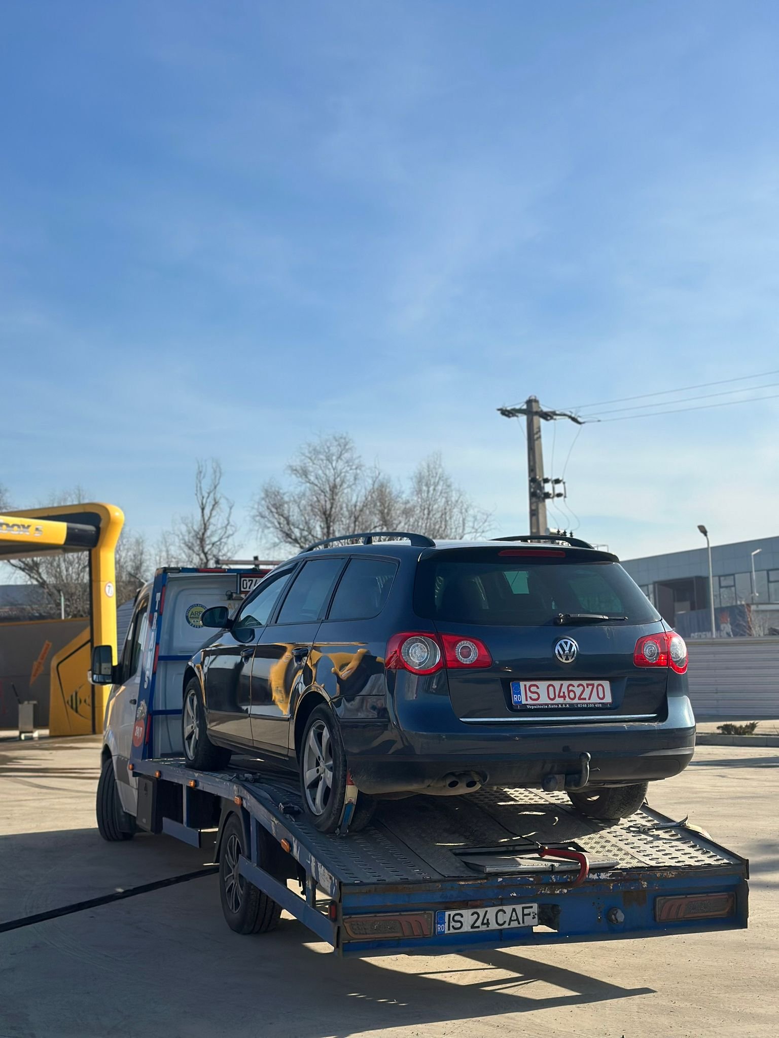 VW Passat break gri urcat pe platforma de tractare la o spalatorie